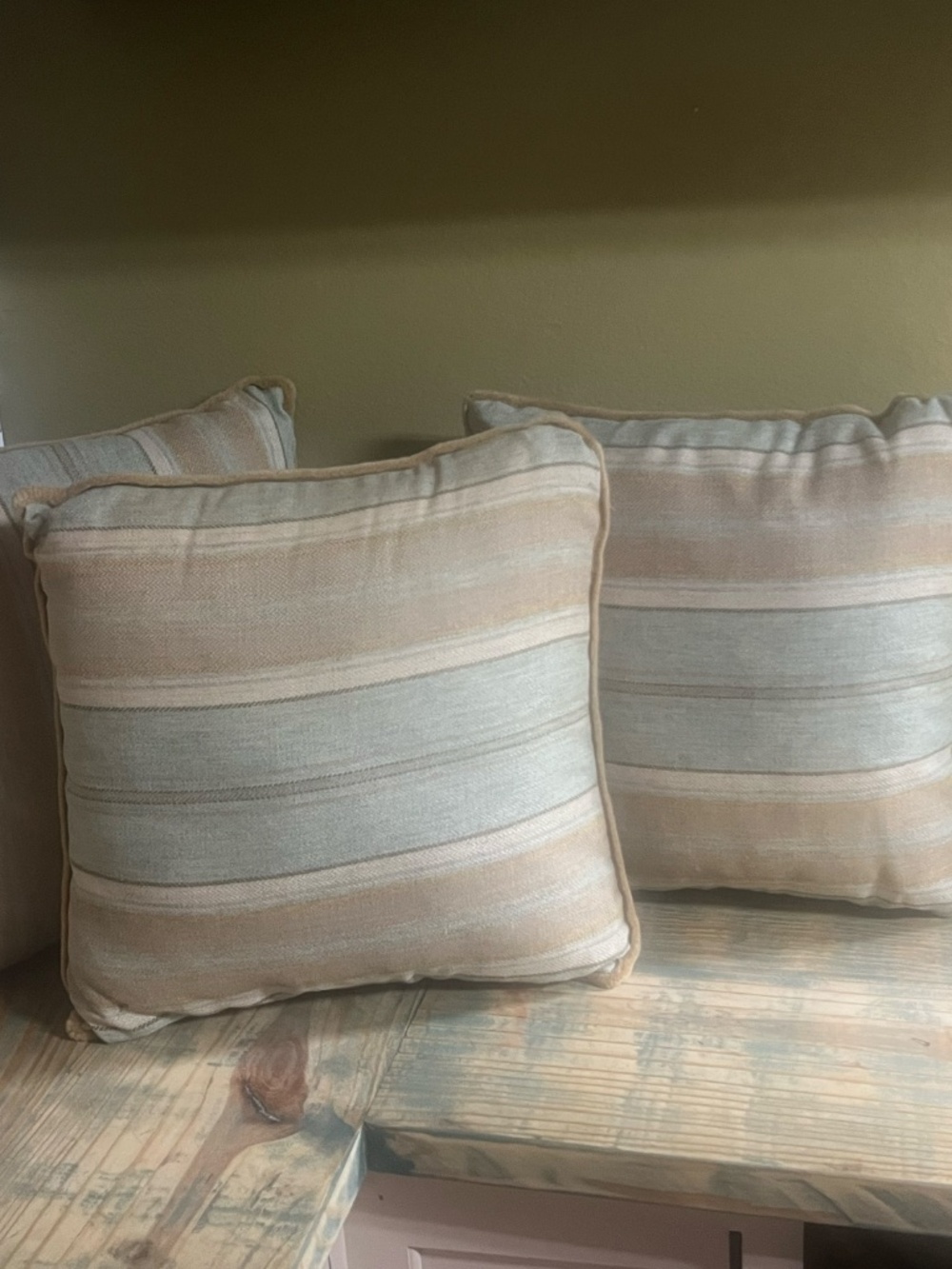 Square decorative throw pillow with a woven striped pattern in muted earthy tone